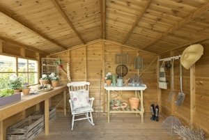 The interior of a decorative potting shed with georgian windows and a workbench