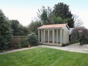 A traditional yet contemporary Burnham Studio situated in a patio overlooking a neat garden, The building has six fully-glazed windows and double door access into the painted interior. 