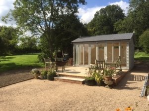 A lovely Burnham garden studio positioned on an area of decking with an apex roof 