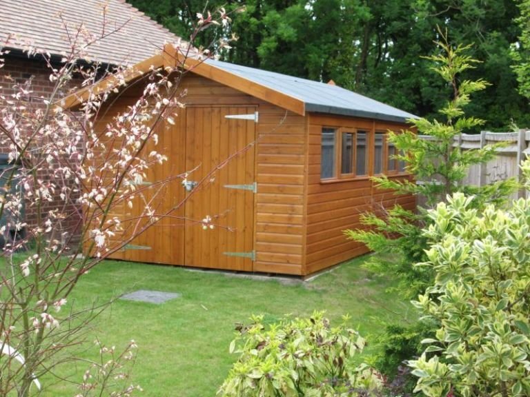 Superior Garden Shed featuring smooth shiplap cladding and an apex roof covered with heavy-duty felt. The exterior is painted in teak. 