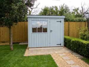 Pent traditional style shed with well kept lawn and path leading up to it. 
