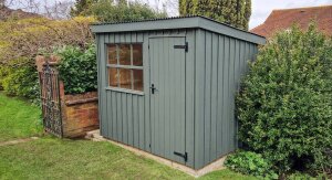 Traditional style pent roof shed painted in a dark mossy green